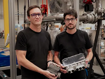 Two people holding electronic equipment in a warehouse